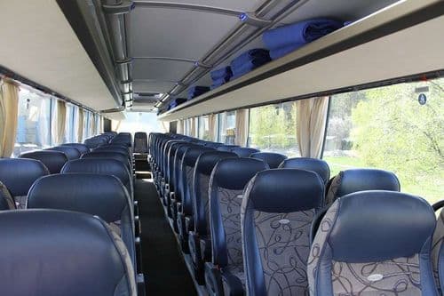 Комфортабельний салон автобуса ТрансТемпо на 54 місця з синіми ергономічними кріслами, індивідуальними пледами та Wi-Fi для поїздок з atatickets.com.