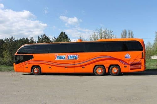 Помаранчевий автобус Neoplan Cityliner L перевізника TransTempo класу Euro-5 на фоні лісопаркової зони — бронювання квитків онлайн на atatickets.com