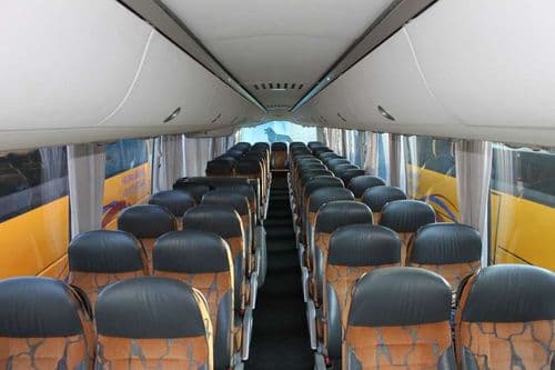 Затишний салон 5-зіркового автобуса ТрансТемпо моделі MAN Lion’s Star (R03) з ергономічними коричневими кріслами та індивідуальним освітленням для подорожей з atatickets.com.