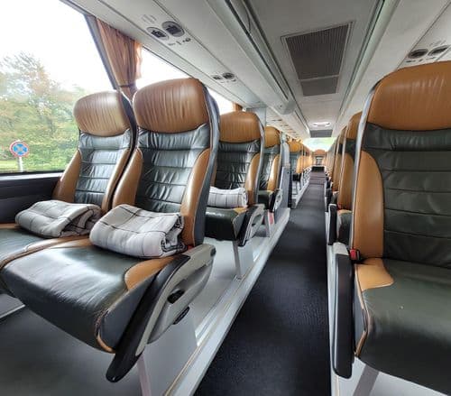 Салон автобуса PAN-BUS з комфортабельними сидіннями для пасажирів, просторий інтер’єр міжміського автобуса з індивідуальними кріслами та достатнім місцем для ніг.