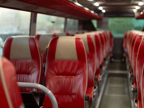 Салон автобуса ПАН-БУС з червоними пасажирськими сидіннями, чистий та впорядкований інтер’єр міжміського автобуса для комфортних поїздок.