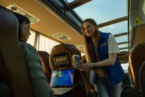 Стюардеса East West Eurolines обслуговує пасажира в салоні міжнародного автобуса під час рейсу Україна – Європа