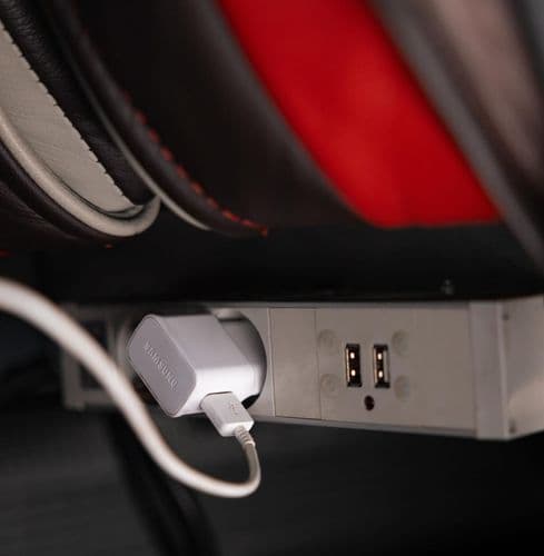 Розетка 220V біля пасажирського місця в автобусі Pavluks-Trans для заряджання смартфонів, ноутбуків та інших пристроїв під час подорожі.