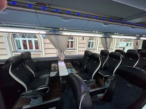 Зона відпочинку з широким столом та зручними сидіннями в салоні автобуса TransTempo — ідеальні умови для роботи та подорожей з atatickets.com.