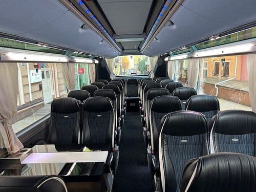 Комфортний салон преміум-автобуса ТрансТемпо (TransTempo) зі шкіряними кріслами та столиками — сервіс високої якості на atatickets.com.